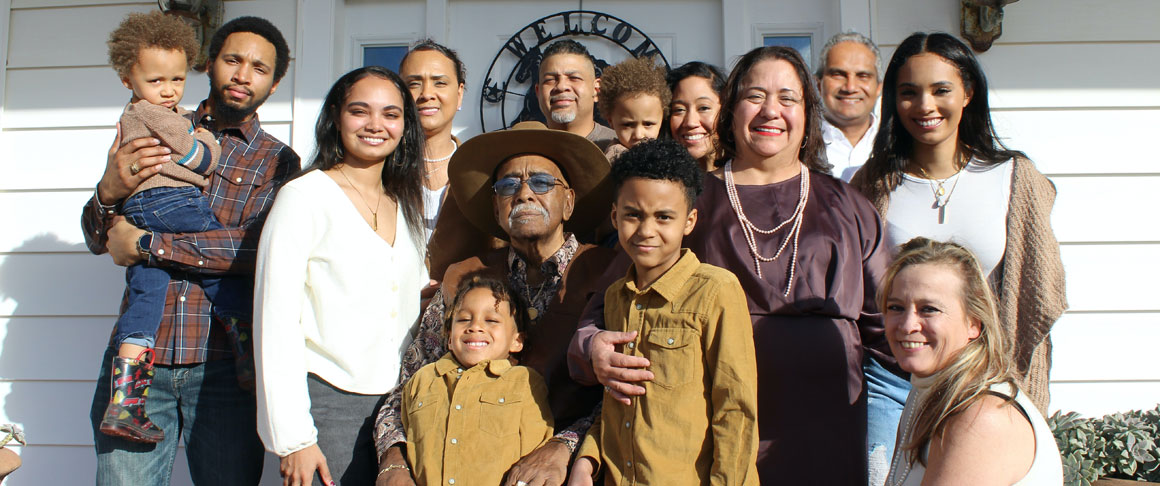 A large family of mixed ethnicity posing for a family photo